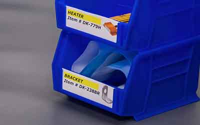 Piccoli contenitori di plastica ordinatamente etichettati con foto di vari tipi di ferramenta.